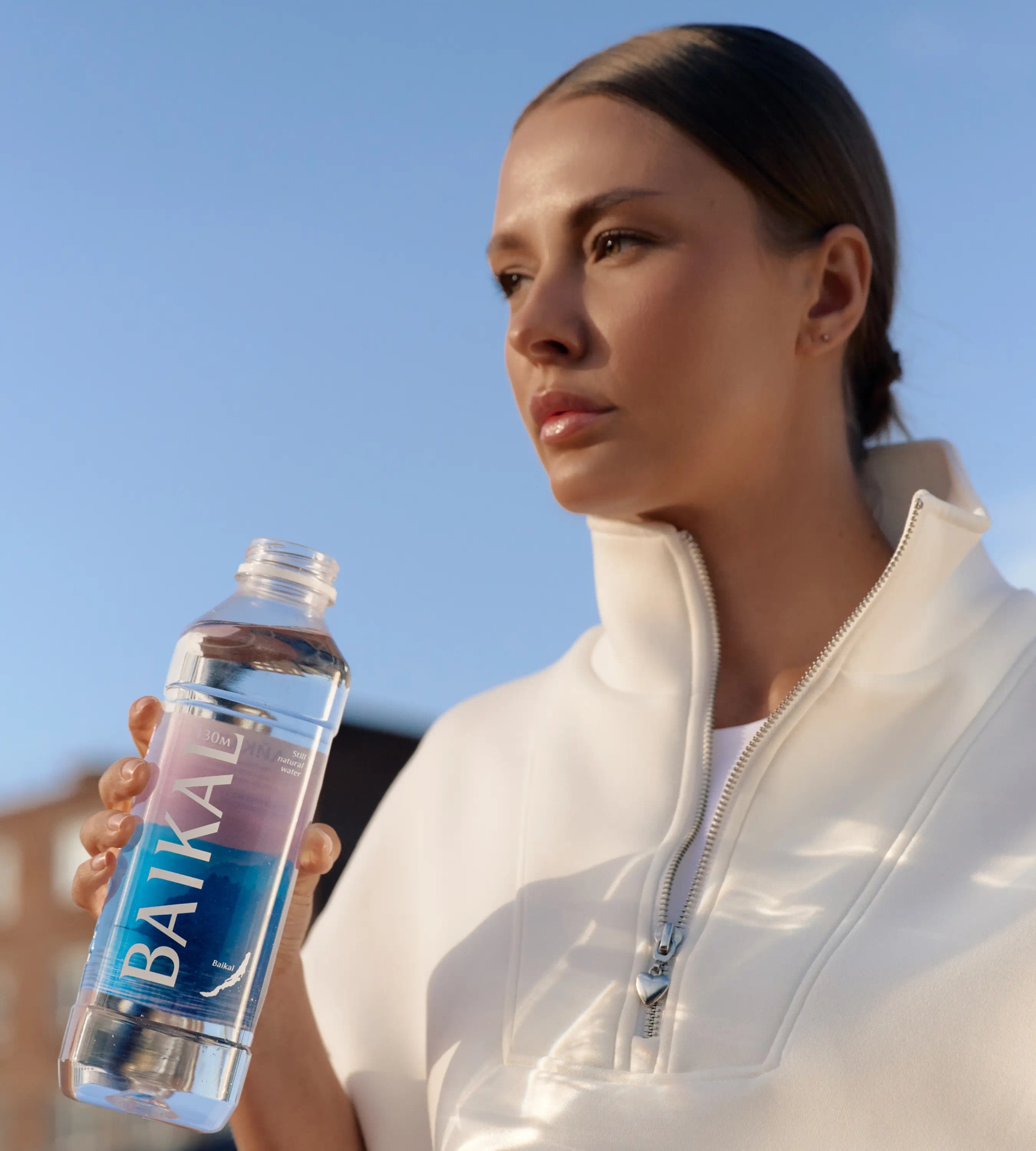 Девушка смотрит вдаль, вода Байкал в руках